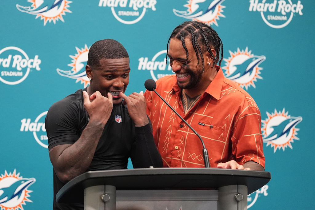 Miami Dolphins' De'Von Achane, left, and Tua Tagovailoa, right, laugh during a news conference after the team's NFL football game against the New York Jets, Monday, Sept. 29, 2025, in Miami Gardens, Fla. (AP Photo/Rebecca Blackwell)