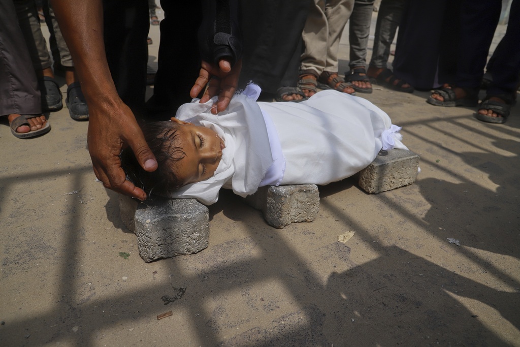 The body of 5-year-old Jamal al-Najjar is placed on the ground atop bricks before a funeral prayer after he died at Nasser Hospital in Khan Younis, southern Gaza Strip, Tuesday, Aug. 12, 2025. The head of Nasser's pediatrics unit said Jamal, who was born with rickets, died from severe malnutrition. (AP Photo/Mariam Dagga)