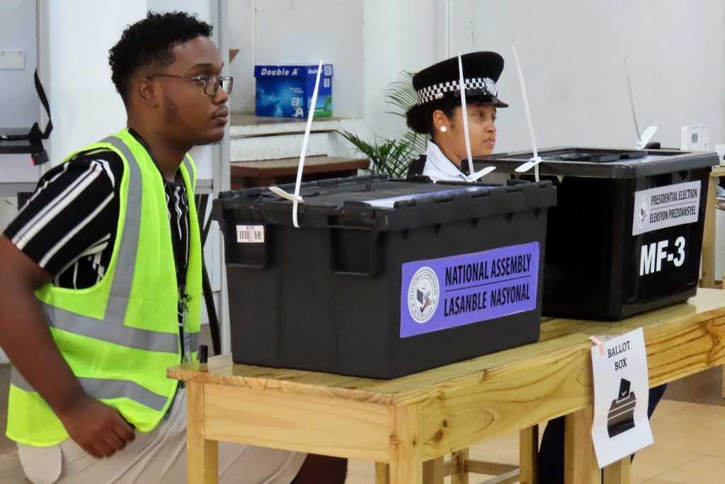 Electoral commission staff monitor voting inside a classroom as people cast their votes at Bel Eau Primary School, Bel Air, Seychelles, on Saturday, Sep. 27, 2025. (AP Photo/Emilie Chetty)