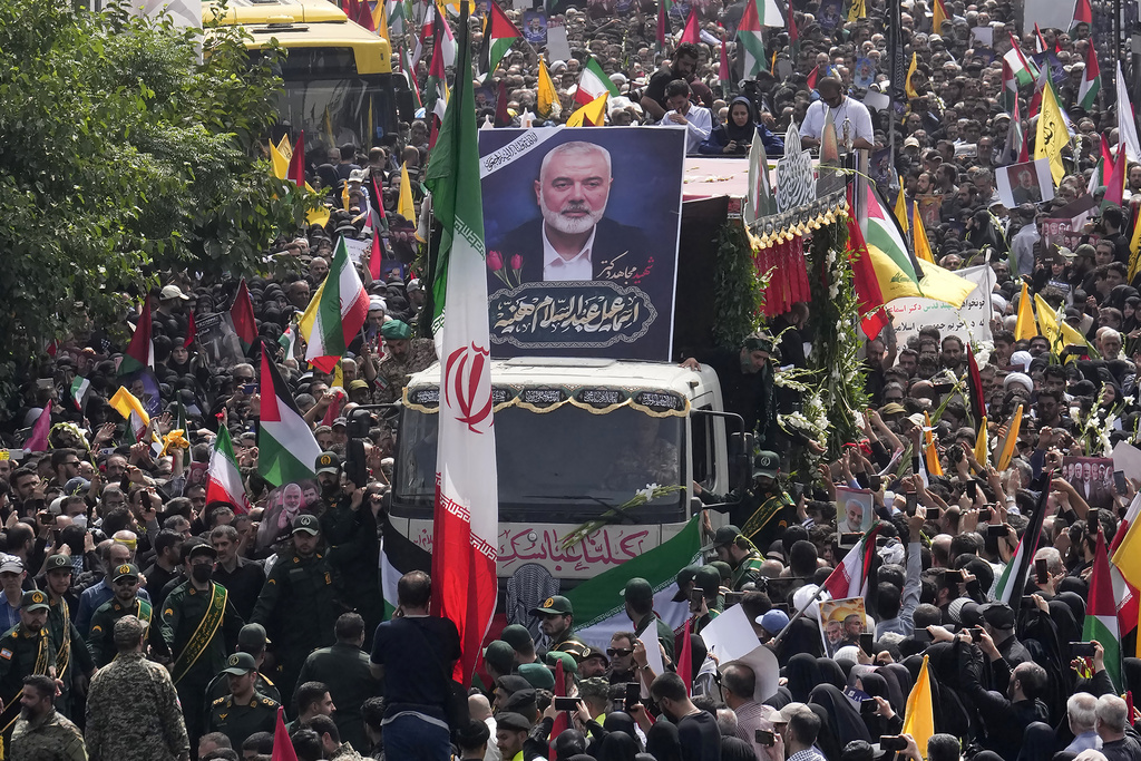 FILE- Iranians follow a truck, center, carrying the coffins of Hamas leader Ismail Haniyeh and his bodyguard who were killed in an assassination blamed on Israel on Wednesday, during their funeral ceremony at Enqelab-e-Eslami (Islamic Revolution) Sq. in Tehran, Iran, Aug. 1, 2024. (AP Photo/Vahid Salemi, file)