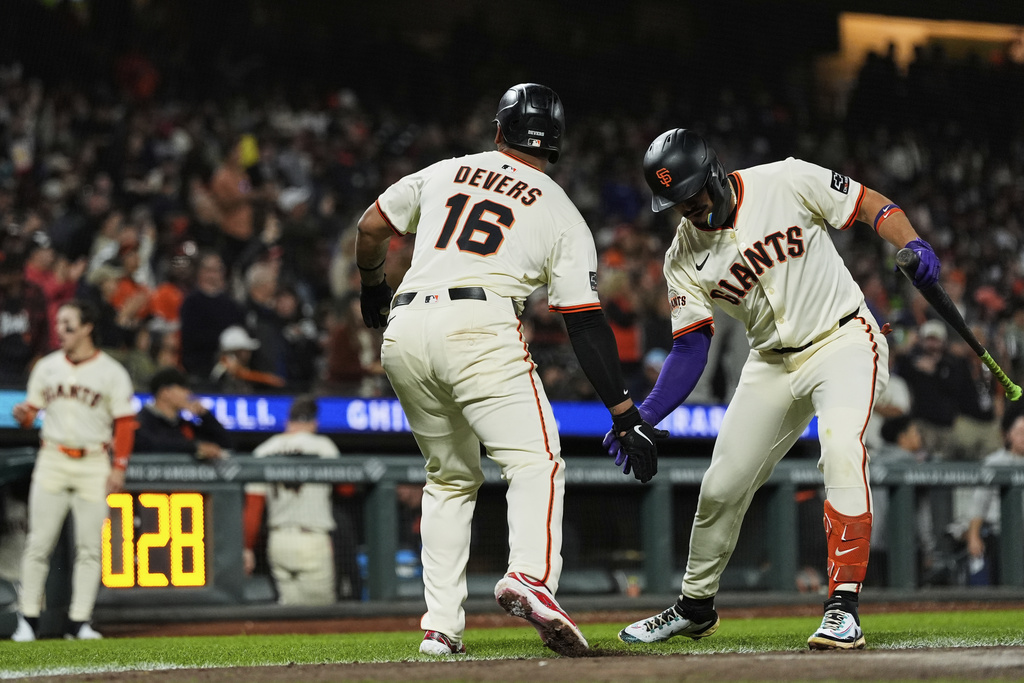 San Francisco Giants' Rafael Devers (16) celebrates with Willy Adames, right, after hitting a solo home run during the fifth inning of a baseball game against the St. Louis Cardinals, Monday, Sept. 22, 2025, in San Francisco. (AP Photo/Godofredo A. Vásquez)