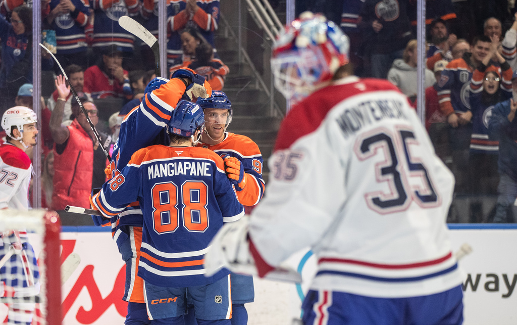 Montreal Canadiens goalie Sam Montembeault (35) looks on as Edmonton Oilers' Darnell Nurse (25), Andrew Mangiapane (88) and Connor McDavid (97) celebrate a goal during second period NHL action, in Edmonton on Thursday, Oct. 23, 2025. (Jason Franson/The Canadian Press via AP)