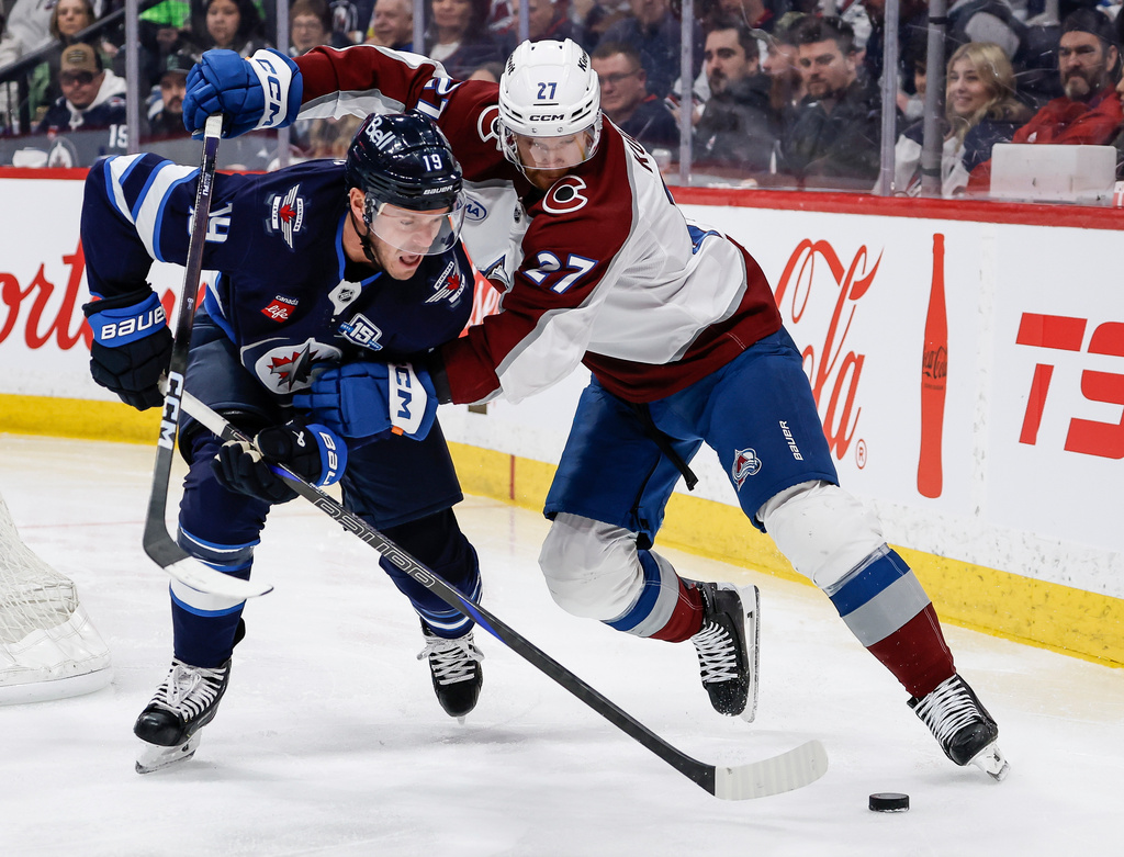 Colorado Avalanche's Brett Kulak (27) defends against Winnipeg Jets' Jonathan Toews (19) during second-period NHL hockey game action in Winnipeg, Manitoba, Thursday, March 26, 2026. (John Woods/The Canadian Press via AP)