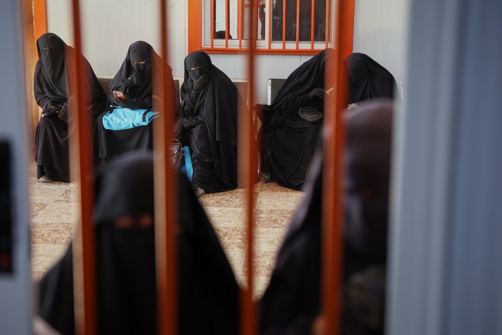 Women wait at a medical center in the al-Hol camp, one of the detention facilities holding thousands of Islamic State group members and their families, now under the control of the Syrian government following the withdrawal of the Syrian Democratic Forces (SDF), in al-Hassakeh province, northeastern Syria, Wednesday, Feb. 4, 2026. (AP Photo/Ghaith Alsayed)