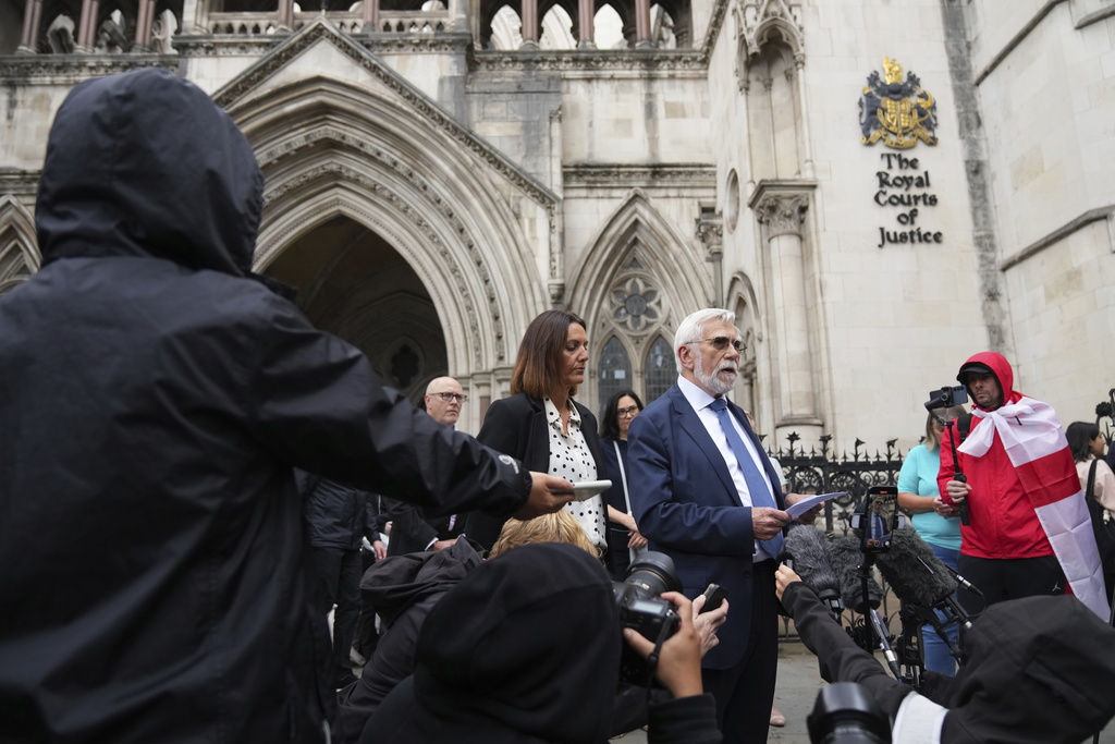 Ken Williamson, Councillor of Epping Forest District Council, center, speaks to press after the judgment due in Home Office and hotel owner's appeal bids against Epping asylum seeker ruling, at The Royal Courts Of Justice in London, Friday, Aug. 29, 2025. (AP Photo/ Joanna Chan)