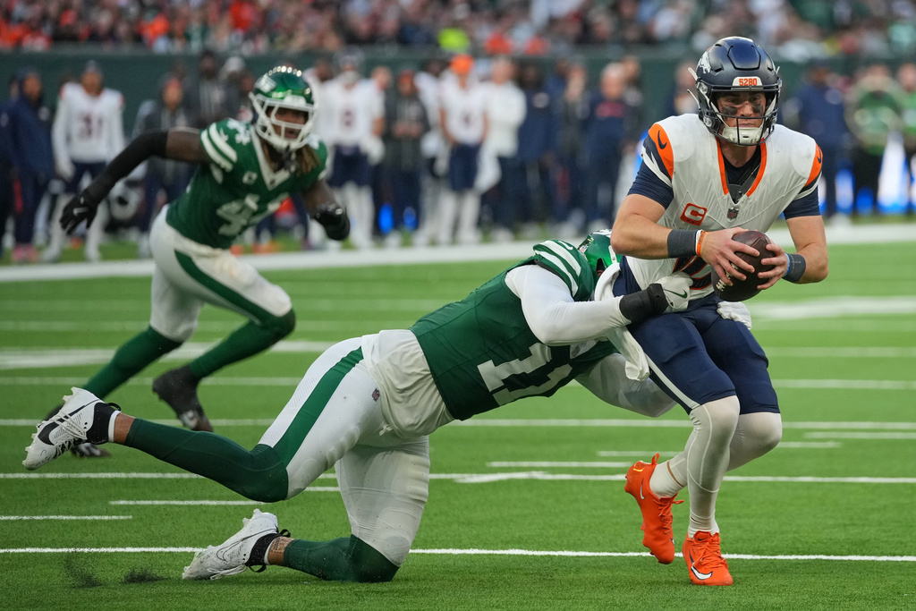 Denver Broncos quarterback Bo Nix (10) is sacked by New York Jets linebacker Jermaine Johnson II (11) in the second half of an NFL football game between the Denver Broncos and the New York Jets, Sunday, Oct. 12, 2025, in London. (AP Photo/Kin Cheung)