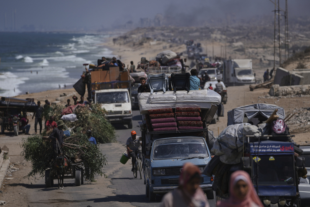 Displaced Palestinians fleeing northern Gaza carry their belongings along the coastal road toward southern Gaza, Tuesday, Sept. 9, 2025, after the Israeli army issued evacuation orders from Gaza City. (AP Photo/Jehad Alshrafi)
