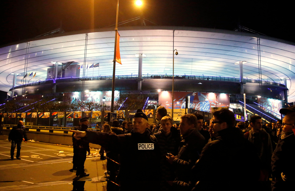 FILE - A police officer directs people outside the Stade de France stadium during the international friendly soccer France against Germany, in Saint Denis, outside of Paris, France, Nov. 13, 2015. (AP Photo/Michel Euler, File)