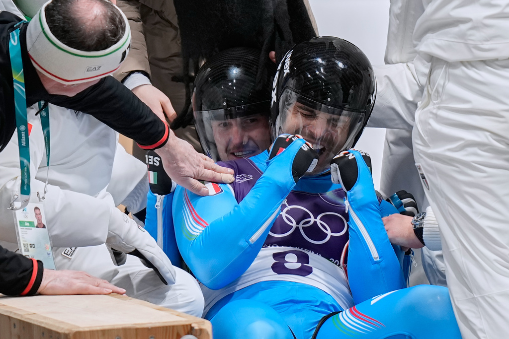 Italy's gold medalists Emanuel Rieder, right, and Simon Kainzwaldner, left, celebrate as they arrive at the finish during a men's doubles luge run at the 2026 Winter Olympics, in Cortina d'Ampezzo, Italy, Wednesday, Feb. 11, 2026. (AP Photo/Aijaz Rahi)