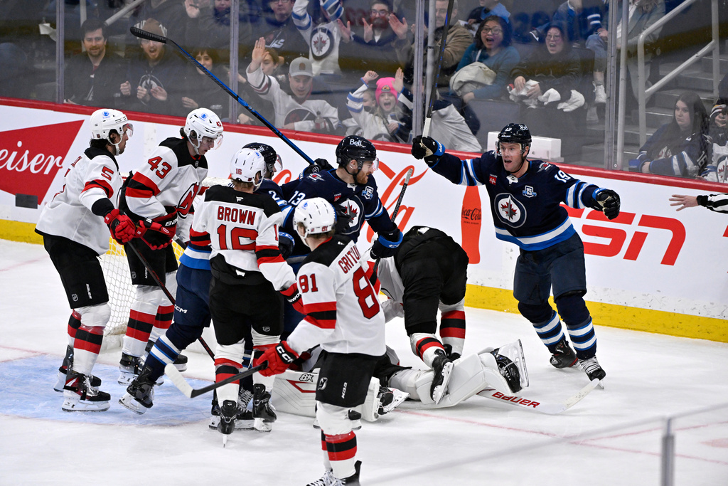 Winnipeg Jets' Gabriel Vilardi (13) celebrates after his goal against the New Jersey Devils with Jonathan Toews (19) during second-period NHL hockey game action in Winnipeg, Manitoba, Sunday, Jan. 11, 2026. (Fred Greenslade/The Canadian Press via AP)