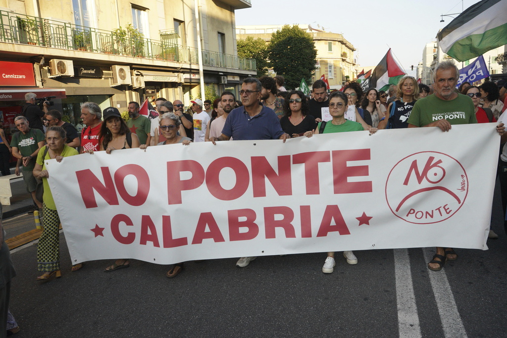 People hold a banner during a demonstration against the bridge in Messina, Italy on Saturday, Aug. 9, 2025 (Francesco Saya/LaPresse via AP)