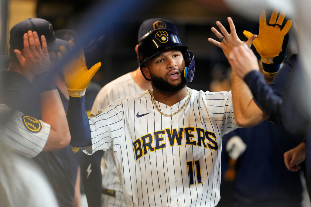 Milwaukee Brewers' Jackson Chourio is congratulated in the dugout after hitting a solo home run during the first inning of a baseball game against the Texas Rangers, Saturday, Aug. 29, 2026, in Milwaukee. (AP Photo/Aaron Gash)