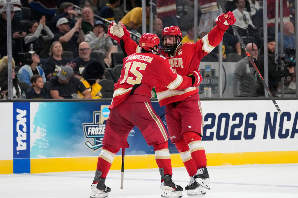 Denver defenseman Kent Anderson, right, celebrates after scoring against Michigan in the second overtime of a semifinal game in the NCAA Frozen Four men's college hockey tournament Thursday, April 9, 2026, in Las Vegas. (AP Photo/John Locher)