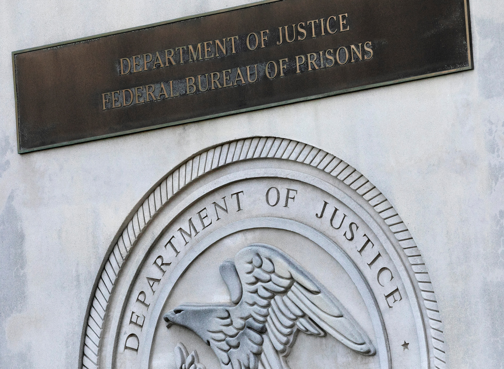 FILE - A sign for the Department of Justice Federal Bureau of Prisons is displayed at the Metropolitan Detention Center in the Brooklyn borough of New York on July 6, 2020. (AP Photo/Mark Lennihan, File)