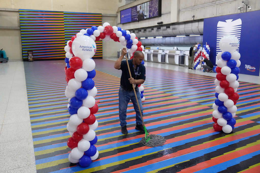 A worker cleans the check-in area ahead of the arrival of a U.S. commercial flight at Simon Bolivar International Airport in Maiquetia, Venezuela, Thursday, April 30, 2026, as direct air service between the United States and Venezuela resumes after seven years. (AP Photo/Ariana Cubillos)