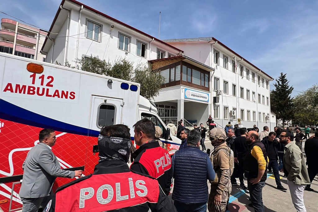 Turkish security forces and emergency staff stand in the courtyard of a secondary school where an assailant opened fire, in Kahramanmaras, Turkey, Wednesday, April 15, 2026, (IHA via AP)