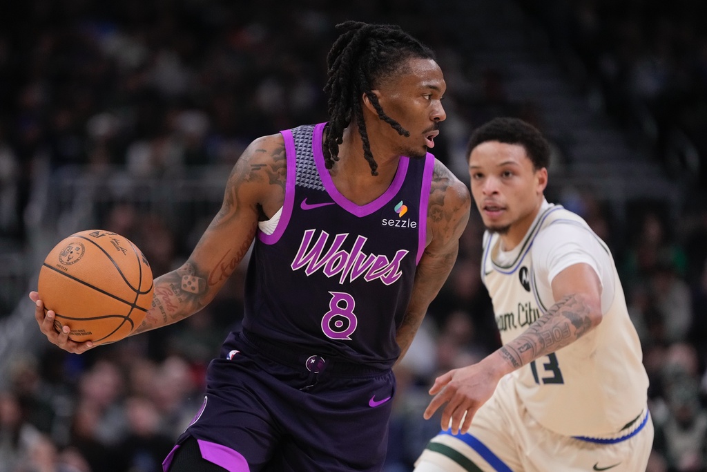 Minnesota Timberwolves' Bones Hyland gets past Milwaukee Bucks' Ryan Rollins during the first half of an NBA basketball game Tuesday, Jan. 13, 2026, in Milwaukee. (AP Photo/Morry Gash)