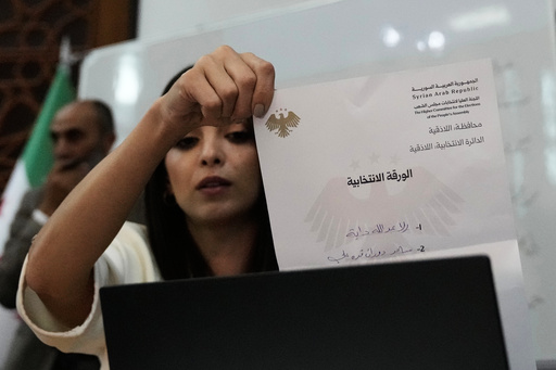 A Syrian election official shows a ballot paper during the counting of ballots, shortly after polling stations closed at Latakia's Governor building, in the coastal city of Latakia, Syria, Sunday, Oct. 5, 2025. (AP Photo/Hussein Malla) A Syrian election official shows a ballot paper during the counting of ballots, shortly after polling stations closed at Latakia's Governor building, in the coastal city of Latakia, Syria, Sunday, Oct. 5, 2025. (AP Photo/Hussein Malla)