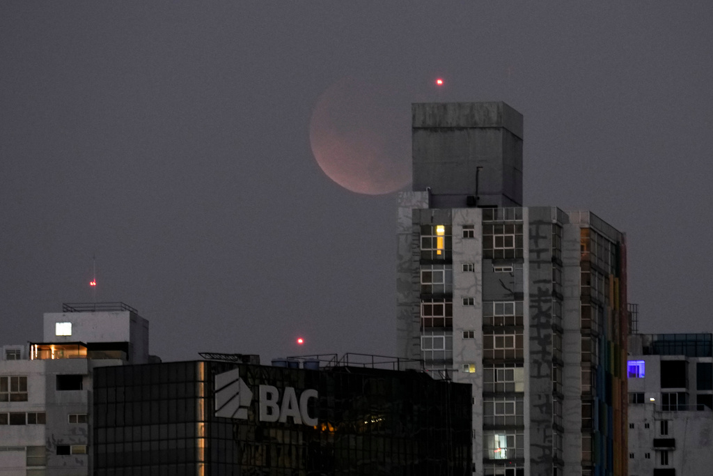 A total lunar eclipse is seen from Panama City before sunrise, Tuesday, March 3, 2026. (AP Photo/Matias Delacroix)