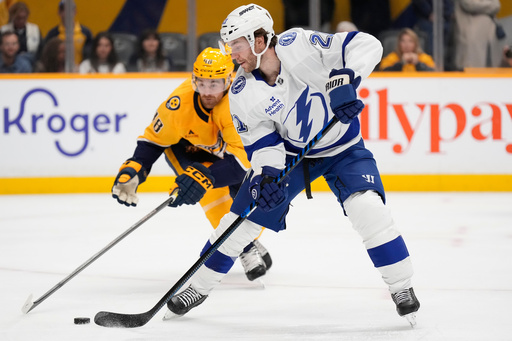 Tampa Bay Lightning center Brayden Point (21) moves the puck past Nashville Predators defenseman Nick Perbix (48) during the first period of an NHL hockey game Tuesday, Oct. 28, 2025, in Nashville, Tenn. (AP Photo/George Walker IV) Tampa Bay Lightning center Brayden Point (21) moves the puck past Nashville Predators defenseman Nick Perbix (48) during the first period of an NHL hockey game Tuesday, Oct. 28, 2025, in Nashville, Tenn. (AP Photo/George Walker IV)