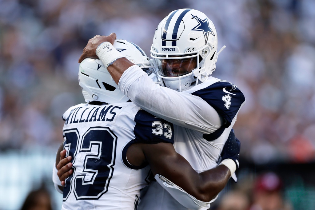 Dallas Cowboys' Dak Prescott hugs Javonte Williams after a touchdown during the second half of an NFL football game against the New York Jets Sunday, Oct. 5, 2025, in East Rutherford, N.J. (AP Photo/Adam Hunger)