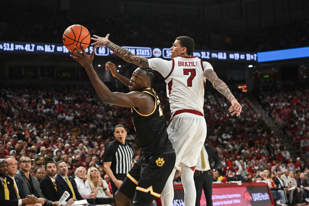 Arkansas forward Trevon Brazile (7) and Missouri guard Mark Mitchell, left, go after a rebound during an NCAA college basketball game Saturday, Feb. 21, 2026, in Fayetteville, Ark. (AP Photo/Michael Woods)