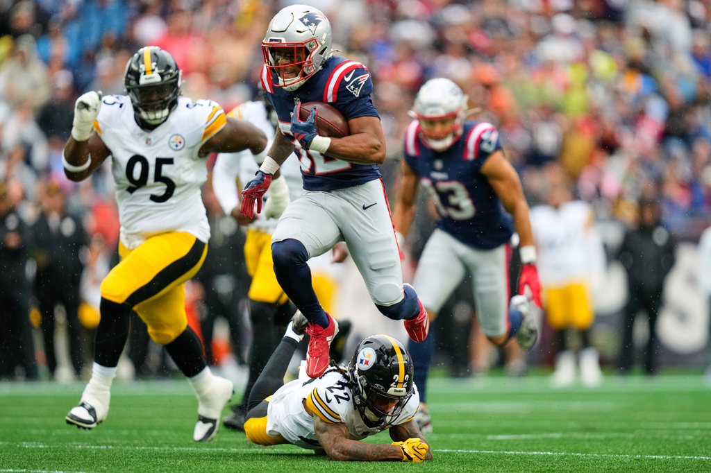 New England Patriots' Treveyon Henderson (32) leaps over Pittsburgh Steelers' Asante Samuel Jr. (22) on his way to a touchdown during the first half of an NFL football game, Sunday, Sept. 20, 2026, in Foxboro, Mass. (AP Photo/Charles Krupa)