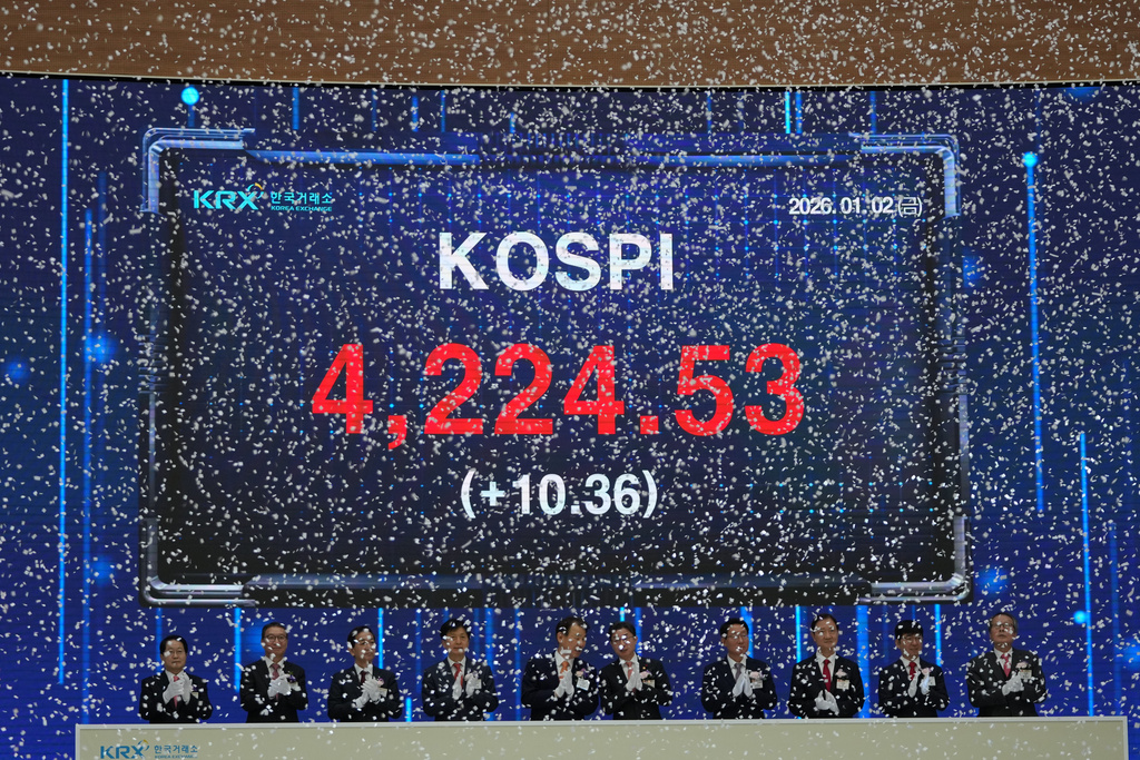 A screen shows the Korea Composite Stock Price Index (KOSPI) as participants applaud during the opening ceremony of the 2026 trading year at the Korea Exchange in Seoul, South Korea, Friday, Jan. 2, 2026. (AP Photo/Lee Jin-man)