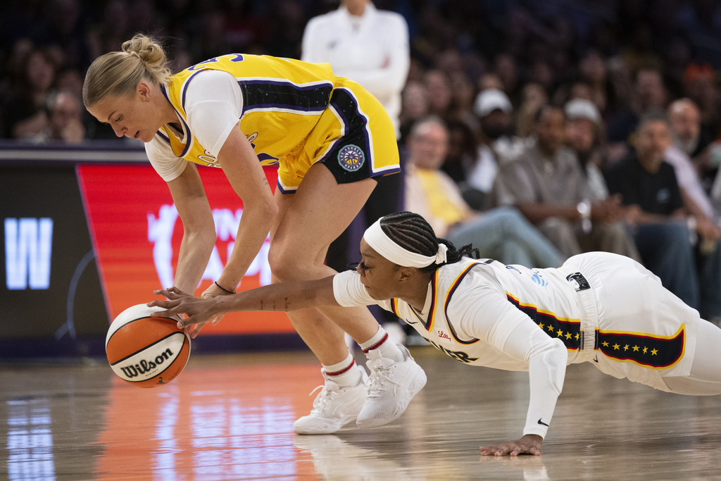 Los Angeles Sparks guard Julie Vanloo, left, and Indiana Fever guard Odyssey Sims vie for the loose ball during the first half of a WNBA basketball game Friday, Aug. 29, 2025, in Los Angeles. (AP Photo/Kyusung Gong)