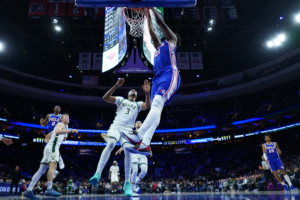 Philadelphia 76ers' Joel Embiid, right, dunks past Milwaukee Bucks' Myles Turner during the first half of an NBA basketball game Tuesday, Jan. 27, 2026, in Philadelphia. (AP Photo/Matt Slocum)