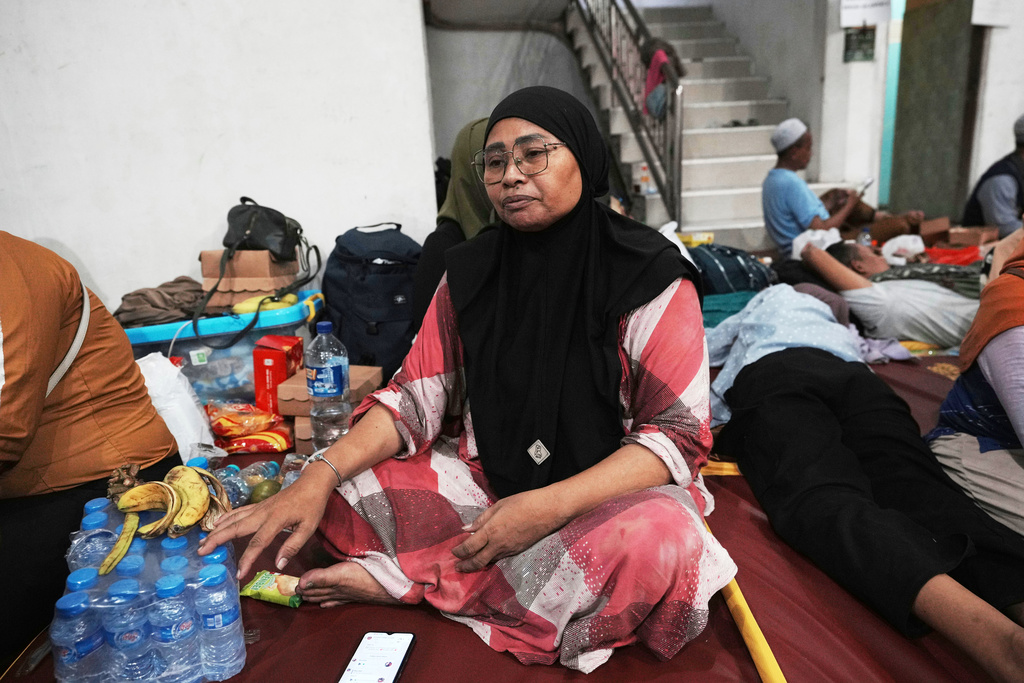 Hafiah, a mother of students, waits in Sidoarjo, East Java, Indonesia, Wednesday, Oct. 1, 2025 as rescue works are underway for the victims trapped under the rubble after a building under construction collapsed at an Islamic boarding school. (AP Photo/Achmad Ibrahim)