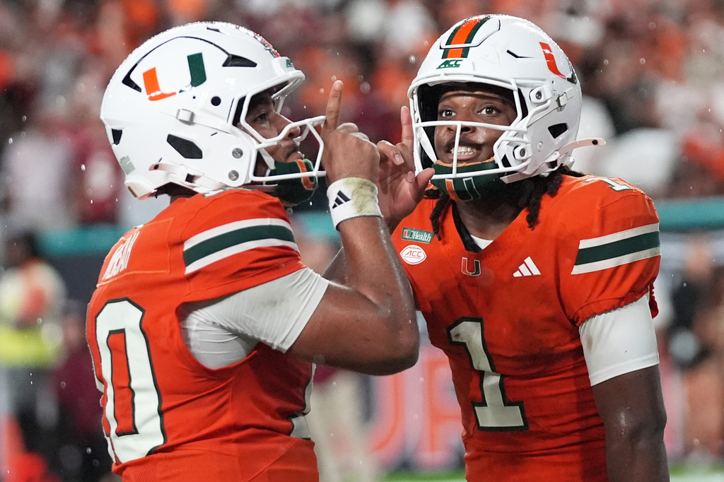 Miami wide receiver Malachi Toney (1) celebrates with quarterback Darian Mensah after scoring a touchdown during the first half of an NCAA college football game against Florida State, Saturday, Oct. 17, 2026, in Miami Gardens, Fla. (AP Photo/Lynne Sladky)