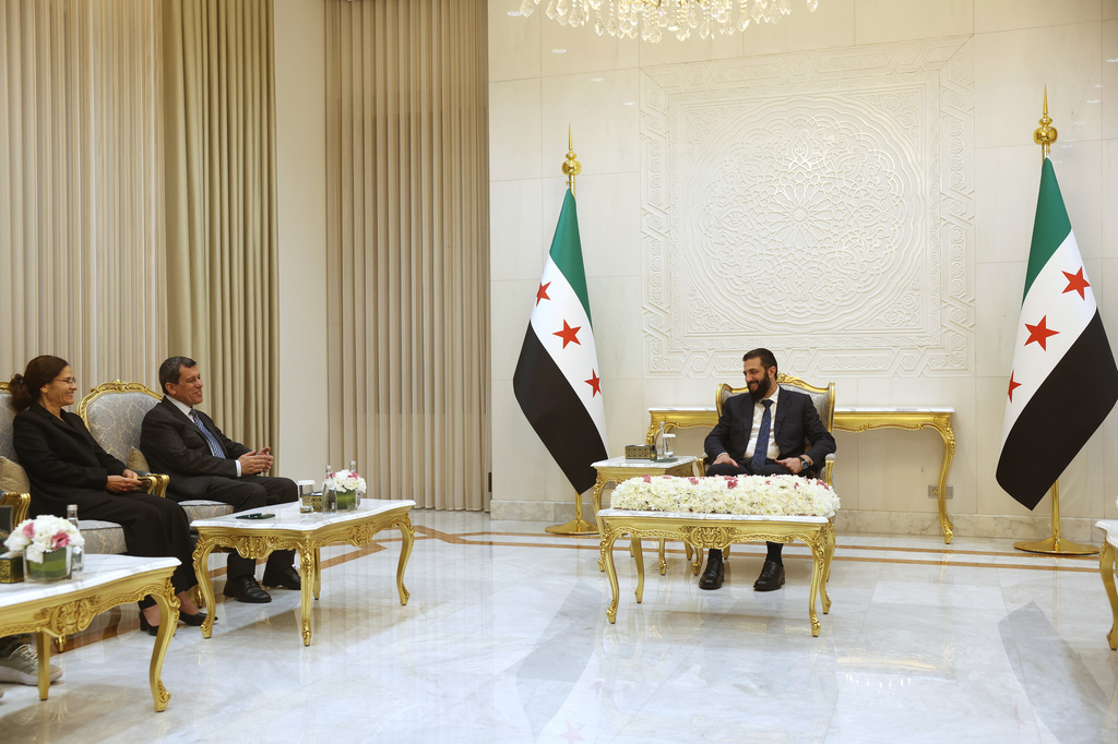 Syrian President Ahmad al-Sharaa, right, meets with the commander of the Kurdish-led Syrian Democratic Forces, Mazloum Abdi, center left, at the presidential palace in Damascus, Tuesday, Aug. 25, 2026. (AP Photo/Ghaith Alsayed)