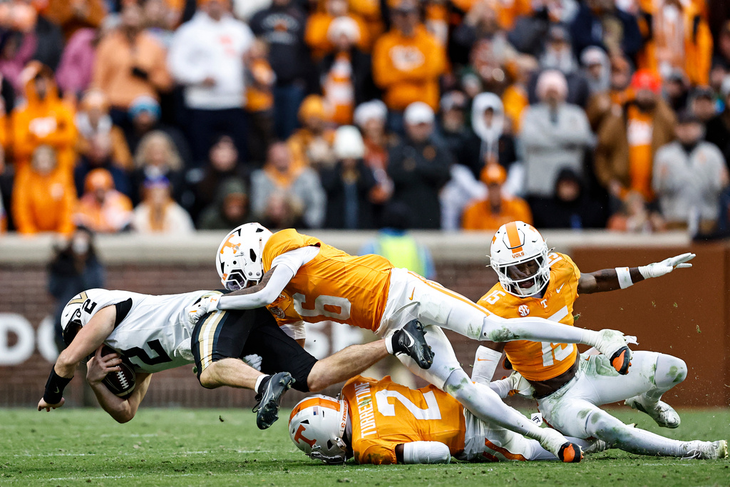 Vanderbilt quarterback Diego Pavia (2) dives forward as he's tackled by Tennessee defensive back Andre Turrentine (2) and defensive back Jalen McMurray (6) during the first half of an NCAA college football game Saturday, Nov. 29, 2025, in Knoxville, Tenn. (AP Photo/Wade Payne)