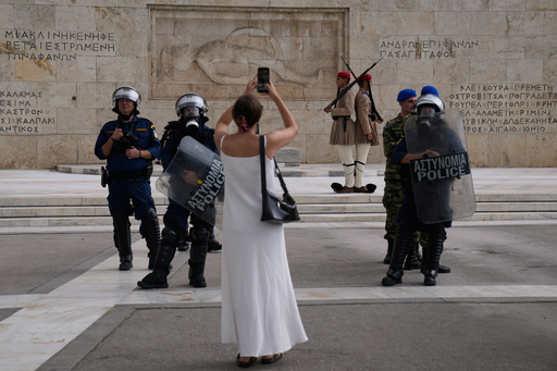 A woman takes a snapshot at the Greek parliament as Greek police stand guard near a protest during a nationwide 24-hour strike in Athens, Greece, Wednesday, Oct. 1, 2025. (AP Photo/Petros Giannakouris) A woman takes a snapshot at the Greek parliament as Greek police stand guard near a protest during a nationwide 24-hour strike in Athens, Greece, Wednesday, Oct. 1, 2025. (AP Photo/Petros Giannakouris)