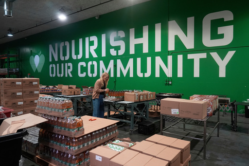 FILE - Mara Sleeter, marketing and communications project manager, stands near boxes of juice while being interviewed in the San Francisco-Marin Food Bank warehouse in San Francisco, July 2, 2025. (AP Photo/Jeff Chiu, File) FILE - Mara Sleeter, marketing and communications project manager, stands near boxes of juice while being interviewed in the San Francisco-Marin Food Bank warehouse in San Francisco, July 2, 2025. (AP Photo/Jeff Chiu, File)