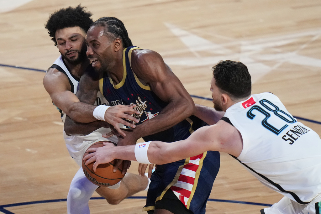 USA Stripes forward Kawhi Leonard, center, dribbles between World guard Jamal Murray, of Canada, left, and forward Alperen Sengun, of Turkey, during the NBA All-Star basketball game Sunday, Feb. 15, 2026, in Inglewood, Calif. (AP Photo/Jae C. Hong)