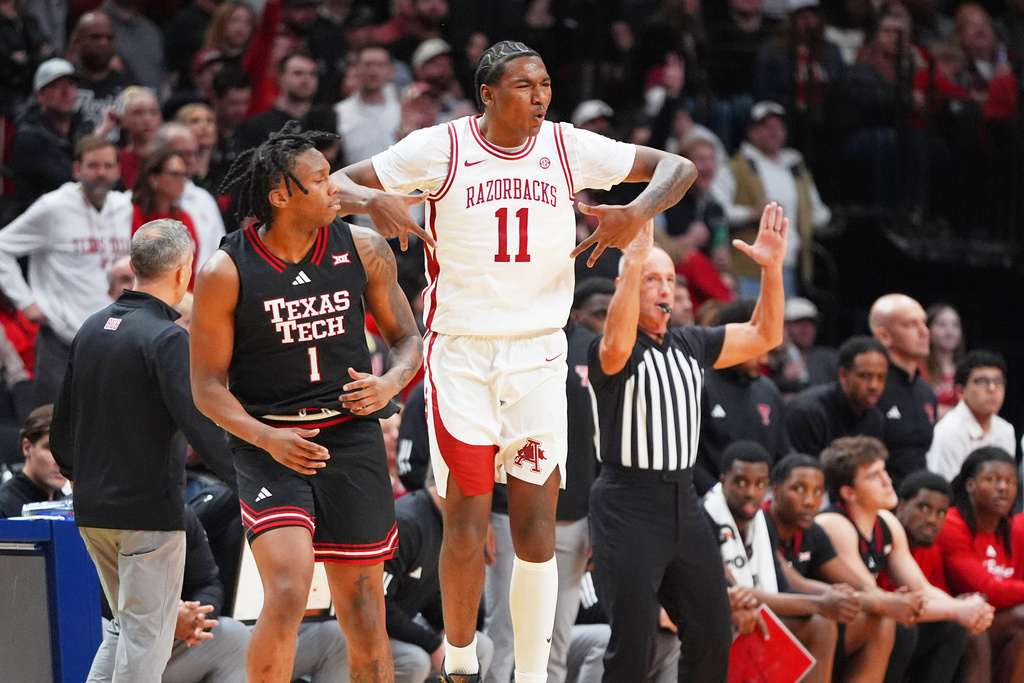 Arkansas forward Karter Knox (11) reacts to scoring a 3-pointer against Texas Tech guard Tyeree Bryan (1) during the first half of an NCAA college basketball game Saturday, Dec. 13, 2025, in Dallas. (AP Photo/LM Otero)