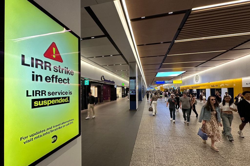 People walk past a sign board at Penn Station in the Manhattan borough of New York announcing that Long Island Rail Road service is suspended because of a worker strike, on Saturday, May 16, 2026. (AP Photo/Michael R. Sisak)