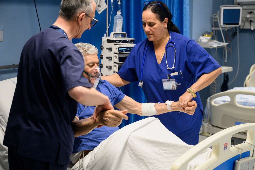 Cuban doctor Daysi Luperon Loforte, right, helps lift up Francesco Ascone, a patient hospitalized in the emergency unit of the Santa Maria degli Ungheresi Hospital of Polistena, in the southern Italian Calabria region, June 16, 2026. (AP Photo/Valeria Ferraro)