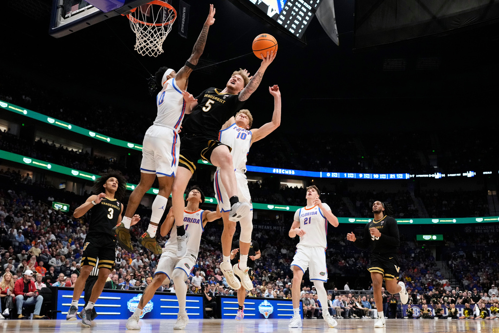Vanderbilt forward Tyler Nickel (5) shoots the ball past Florida guard Boogie Fland (0) and forward Thomas Haugh (10) during the first half of an NCAA college basketball game in the semifinals of the Southeastern Conference tournament Saturday, March 14, 2026, in Nashville, Tenn. (AP Photo/George Walker IV)