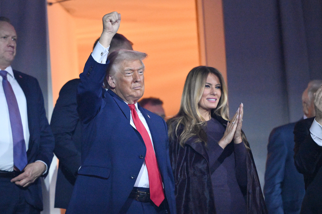 President Donald Trump pumps his fist alongside first lady Melania Trump reach after the draw for the 2026 soccer World Cup at the Kennedy Center in Washington, Friday, Dec. 5, 2025. (Mandel Ngan/Pool Photo via AP)