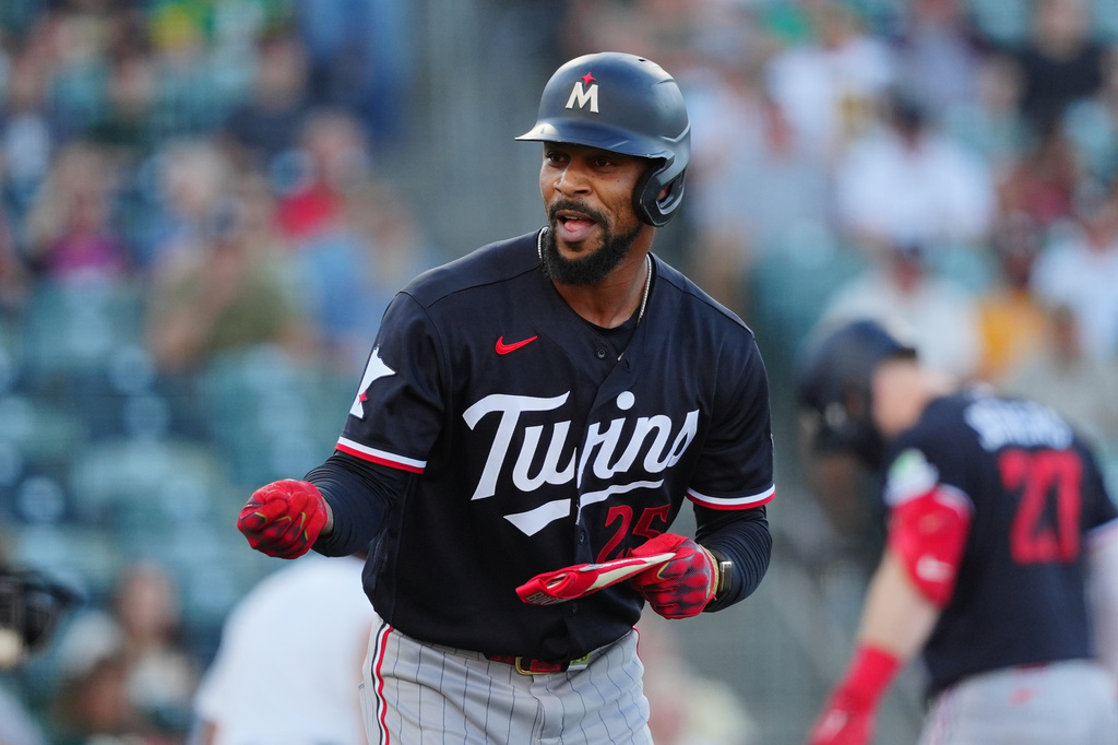 Minnesota Twins' Byron Buxton reacts while running to first base after winning a challenge in the first inning during a baseball game against the Athletics, Monday, Aug. 24, 2026, in West Sacramento, Calif. (AP Photo/Alan Greth)