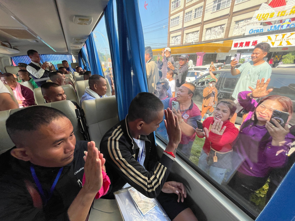 In this photo released by Agence Kampuchea Press (AKP), Cambodian soldiers are welcomed by villagers upon their arrival at Prum border gate, in Pailin province, Cambodia, Wednesday, Dec. 31, 2025, after being captured and held by Thailand. (AKP via AP)