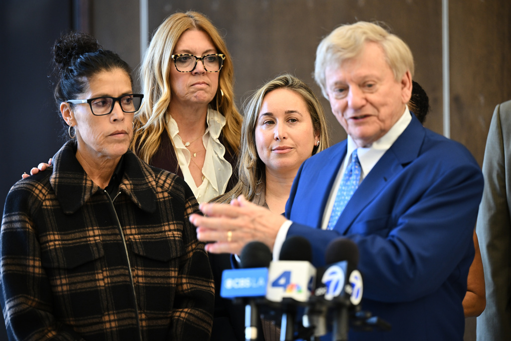 Attorney Russell Hardin Jr. right speaks in front of Tyler Skaggs' widow Carli Skaggs, center, and mother Debbie Skaggs, at left, after a settlement was reached in the wrongful death lawsuit by the family of the Los Angeles Angels pitcher Friday, Dec. 19, 2025, in Orange County Superior Court, in Santa Ana, Calif. (AP Photo/William Liang)