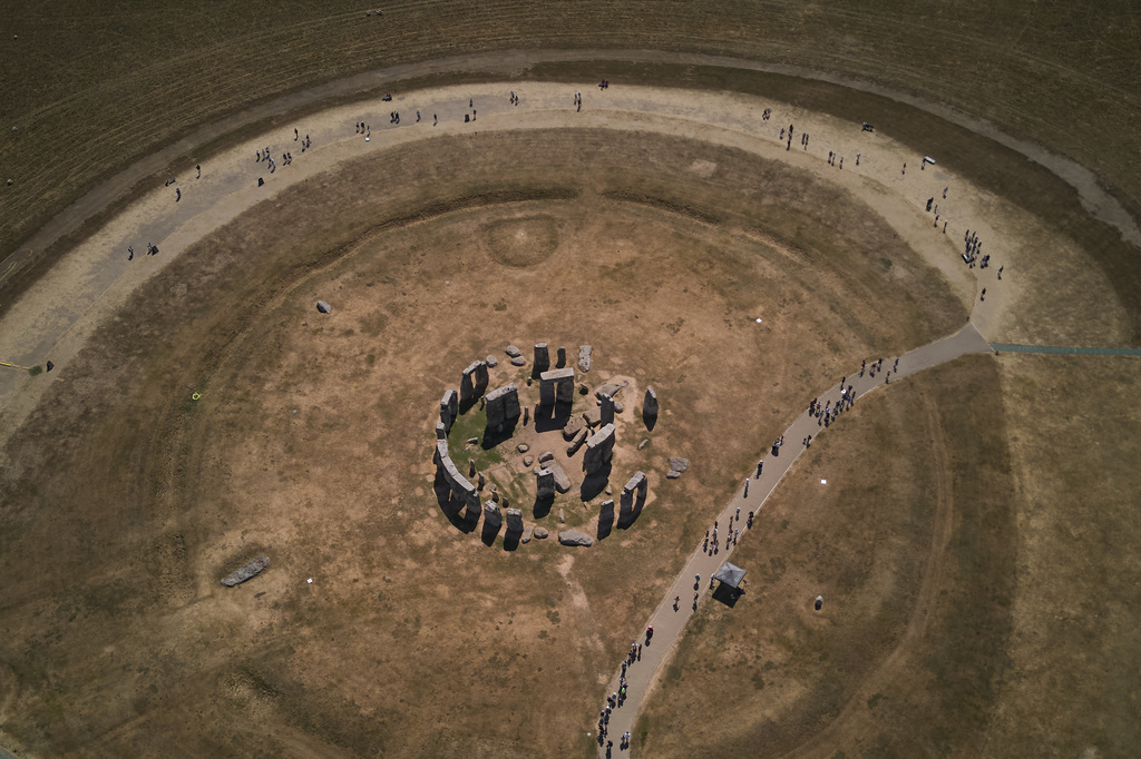 A general view of the ancient stone circle Stonehenge amid dried grass in Wiltshire, England, Thursday, Aug. 13, 2026. (AP Photo/Kin Cheung)