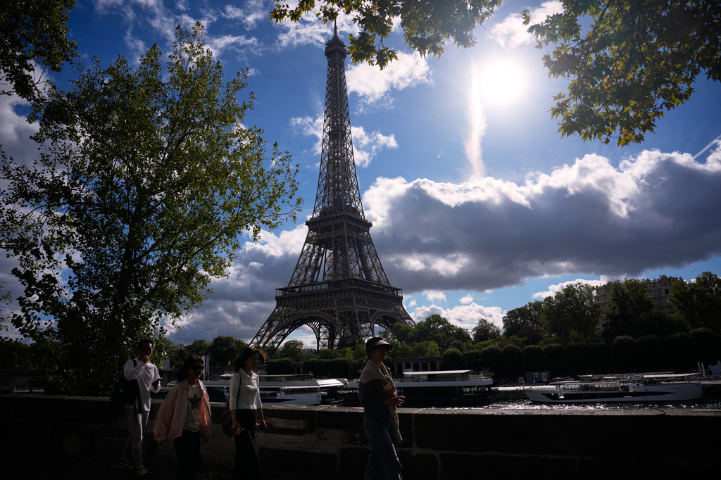 Tourists walk past the Eiffel Tower after it reopened following a one-day strike over restrictions on women during a visit by a Hindu delegation, in Paris, Tuesday, Sept. 8, 2026. (AP Photo/Christophe Ena)