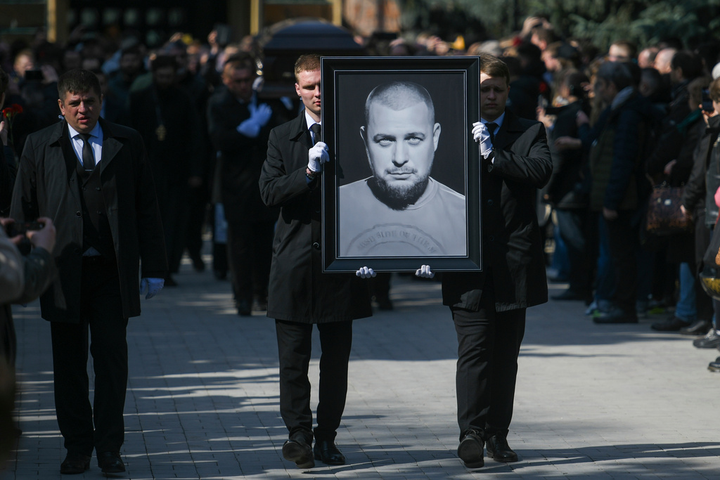 FILE - Cemetery workers carry a portrait of slain Russian military blogger Vladlen Tatarsky during a funeral at the Troyekurovskoye Cemetery in Moscow, Russia, on April 8, 2023. (Anton Velikzhanin, M24/Moscow News Agency via AP, File)