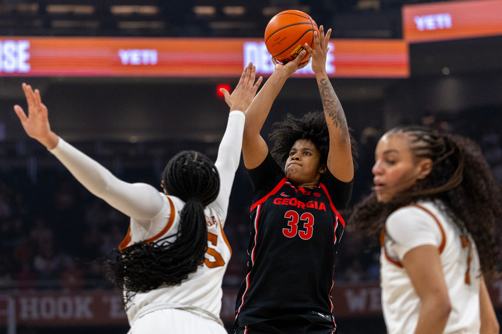 Georgia forward Mia Woolfolk (33) shoots between Texas forward Breya Cunningham, left, and guard Jordan Lee during the first half of an NCAA college basketball game Thursday, Feb. 26, 2026, in Austin, Texas. (AP Photo/Stephen Spillman)