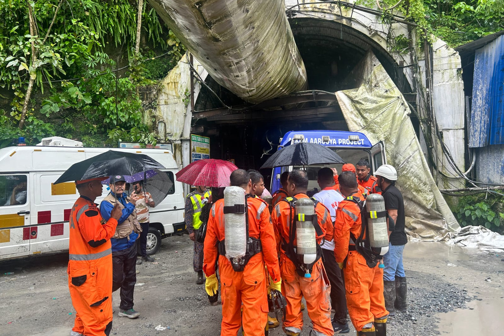Members of the rescue team carry oxygen cylinders outside the entrance to an under-construction tunnel at a hydropower project in Samardung village, about 40 kilometers (25 miles) from Gangtok, India, Tuesday, July 21, 2026. (AP Photo)